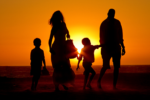 Mother and father stroll on Los Angeles beach with their children